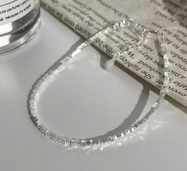 Freya Canada’s I AM ASTERIA Starlight Sterling silver beaded bracelet in a flat lay with newspaper prop