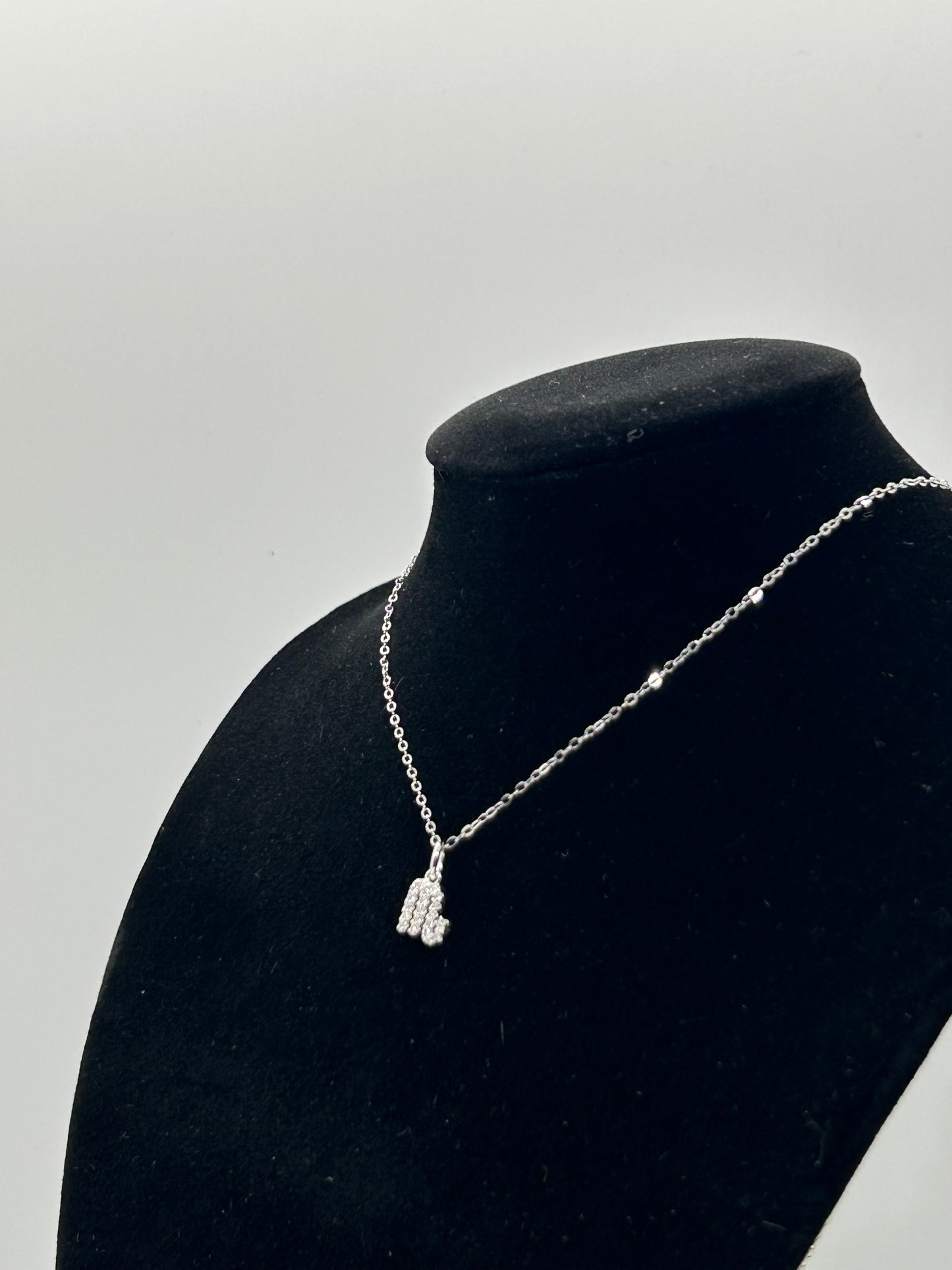 Side shot of Freya Canada’s Scorpio Goddess Pave Charm Necklace. Situated on a black velvet jewelry bust, on a gray background. Ships from Vancouver, B.C.
