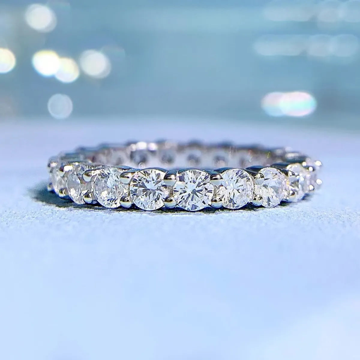 Freya Canada’s I AM ETERNITY Radiant zircon band ring, professional photography, displayed laying flat on a blue background