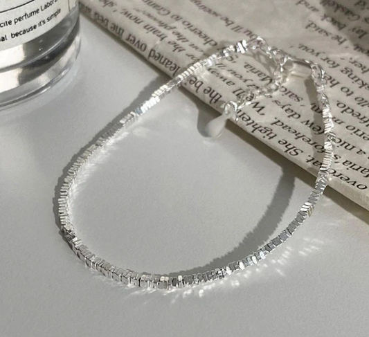 Freya Canada’s I AM ASTERIA Starlight Sterling silver beaded bracelet in a flat lay with newspaper prop