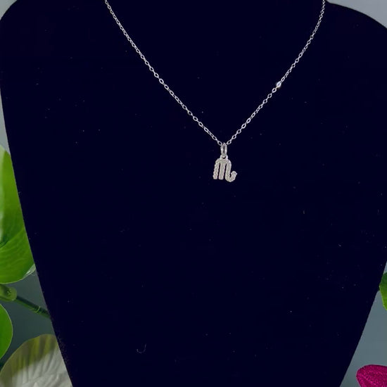 Video of Freya Canada’s Scorpio Goddess Pave Charm Necklace. Pictured with tropical flowers and leaves. Displayed on a black velvet jewelry bust. Ships from Vancouver, B.C. 