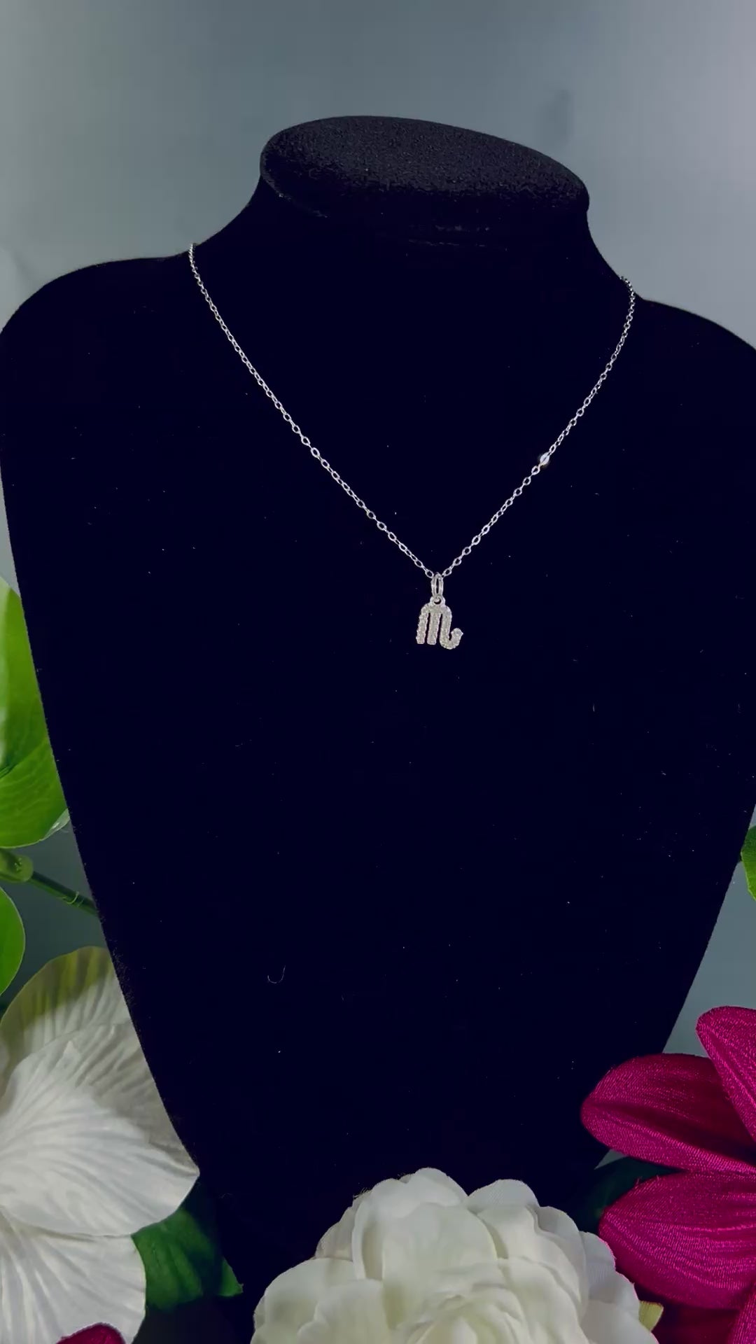 Video of Freya Canada’s Scorpio Goddess Pave Charm Necklace. Pictured with tropical flowers and leaves. Displayed on a black velvet jewelry bust. Ships from Vancouver, B.C. 