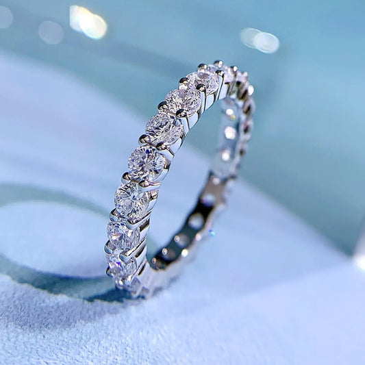 Freya Canada’s I AM ETERNITY Radiant zircon band ring, professional photography, displayed standing up on a blue background 